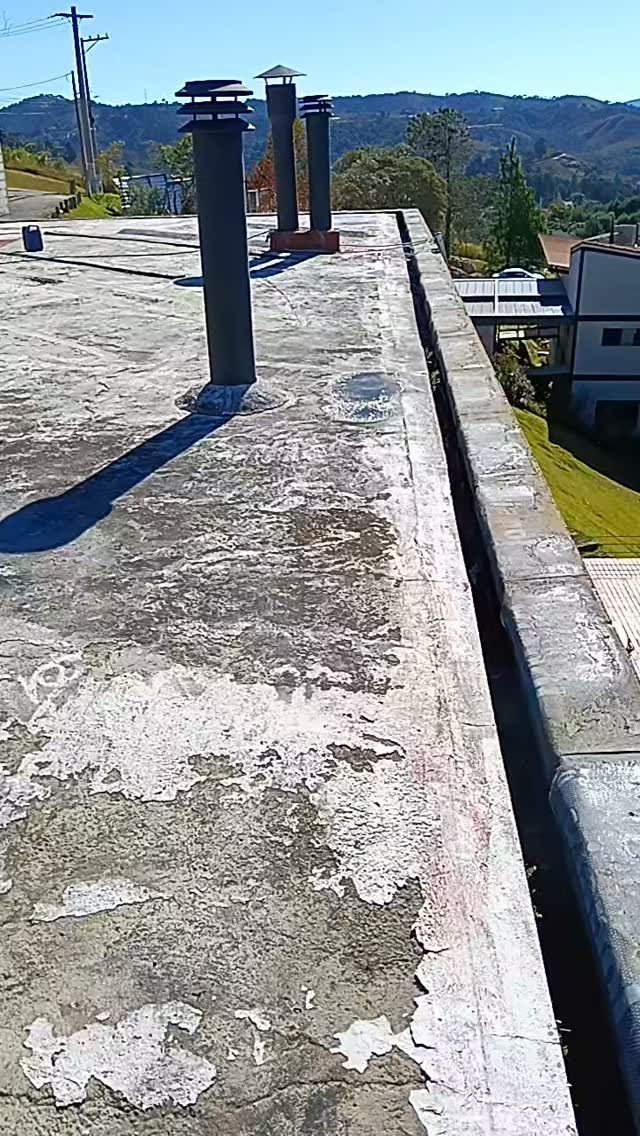 Telhado com impermeabilização desgastada e chaminés antes do serviço